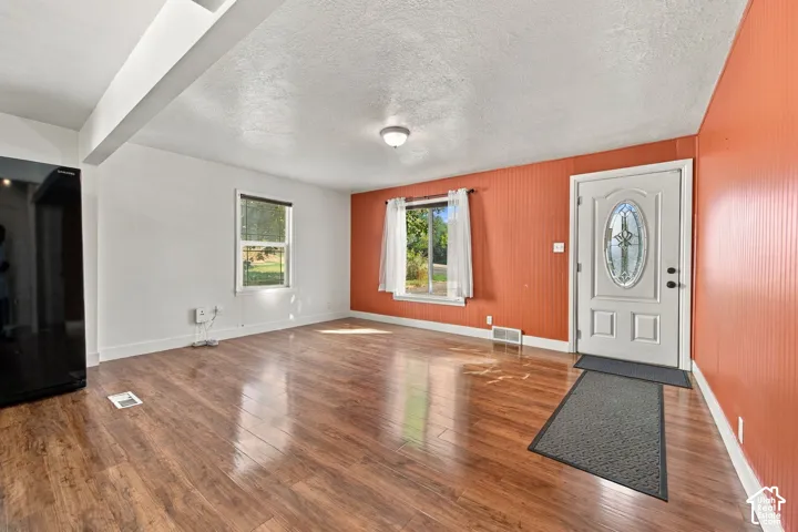 Wood-finish flooring, white walls, and an orange accent wall with vertical paneling