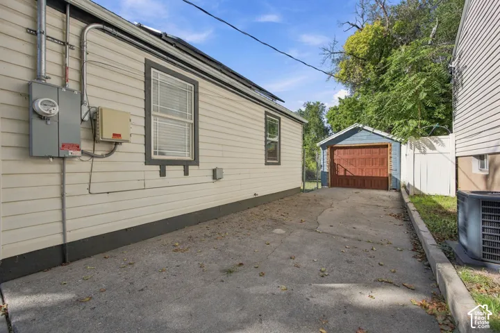 Concrete driveway leading to a detached garage with a wood-finish door