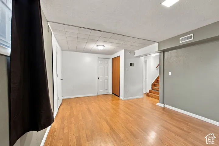 Wood-finish flooring throughout, white interior doors, recessed lighting, and wooden stair treads