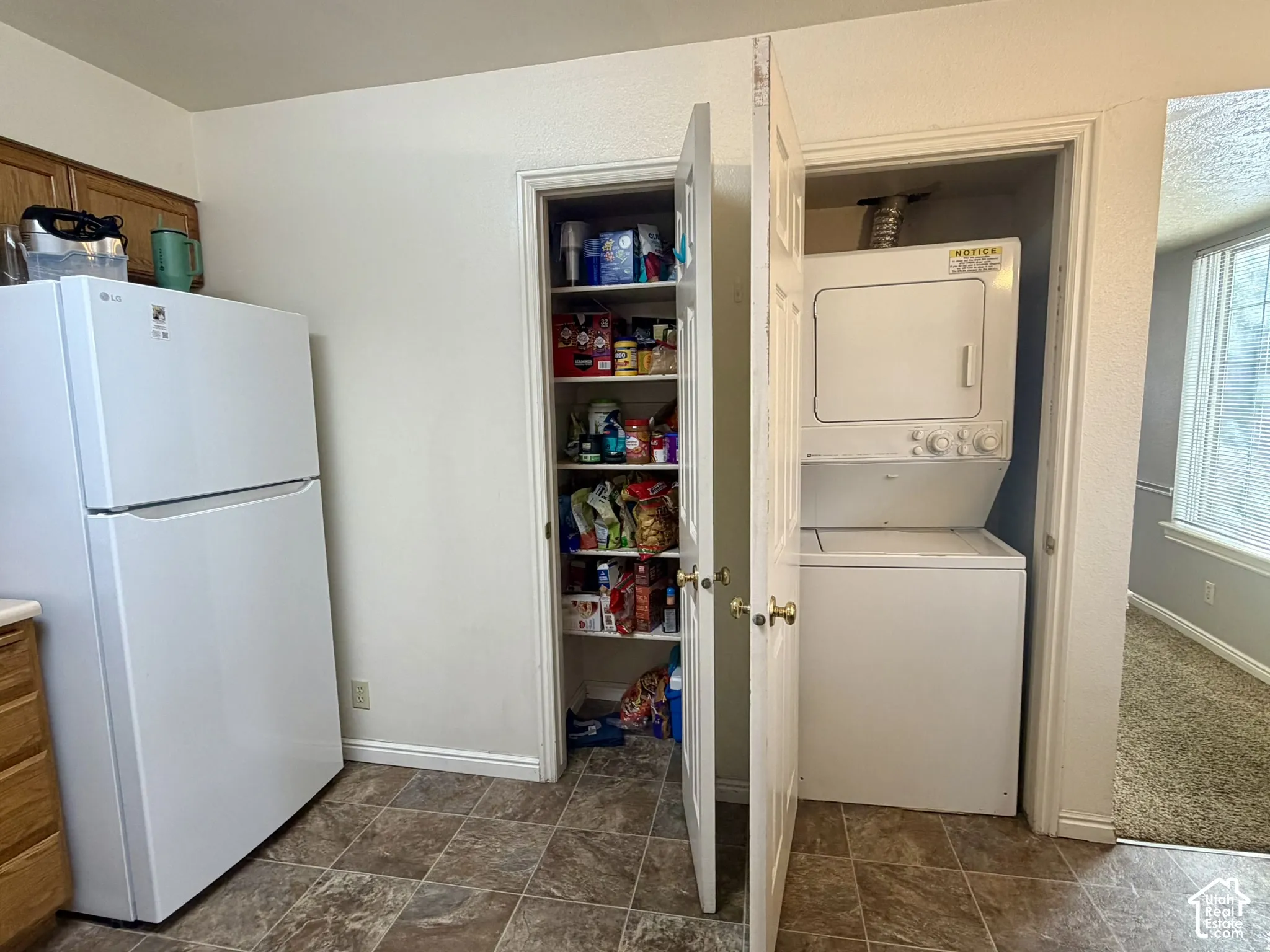 Laundry closet with stacked washer and dryer.  Kitchen pantry.