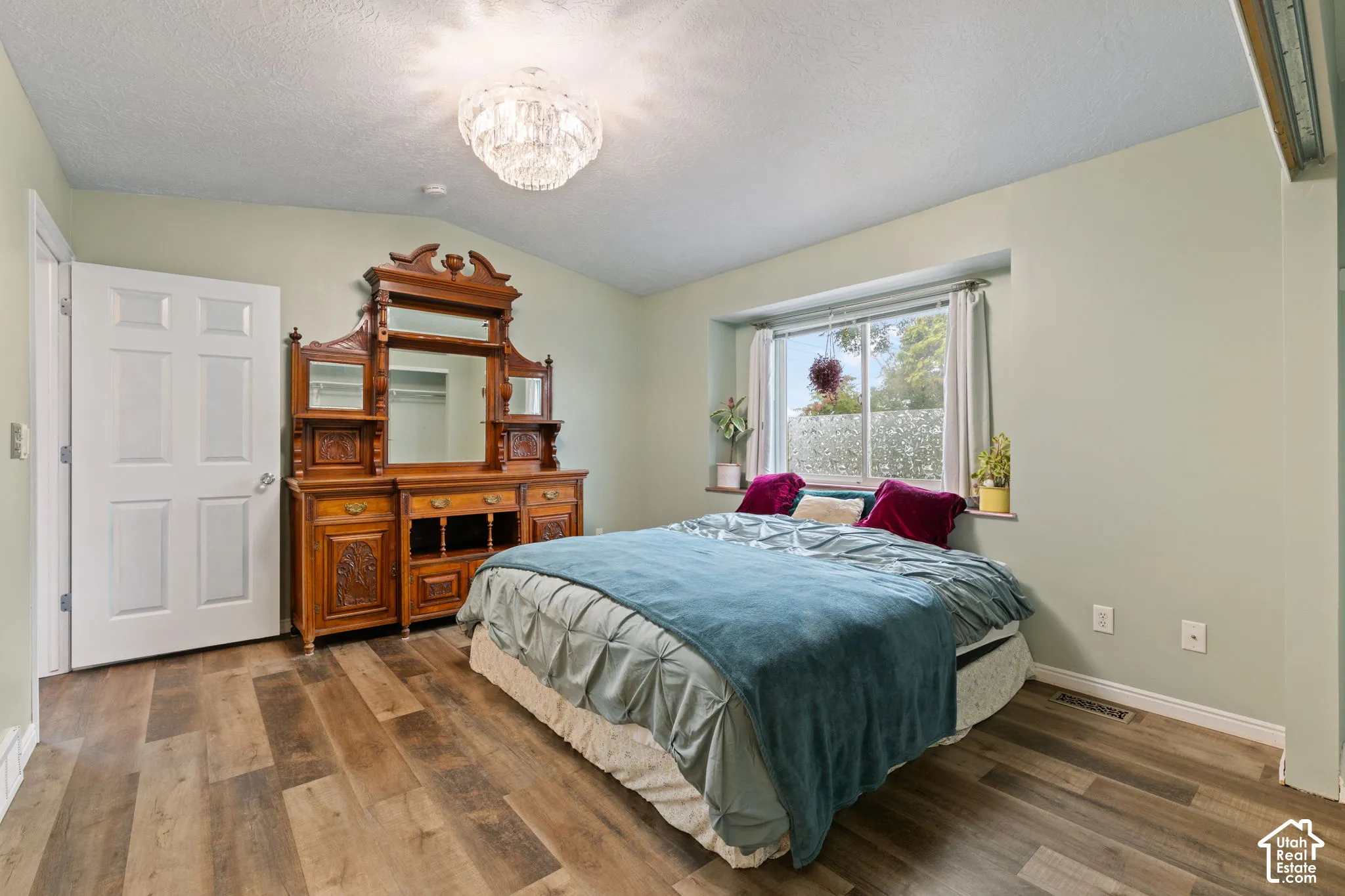 Wood-finish flooring, recessed window, and overhead chandelier lighting