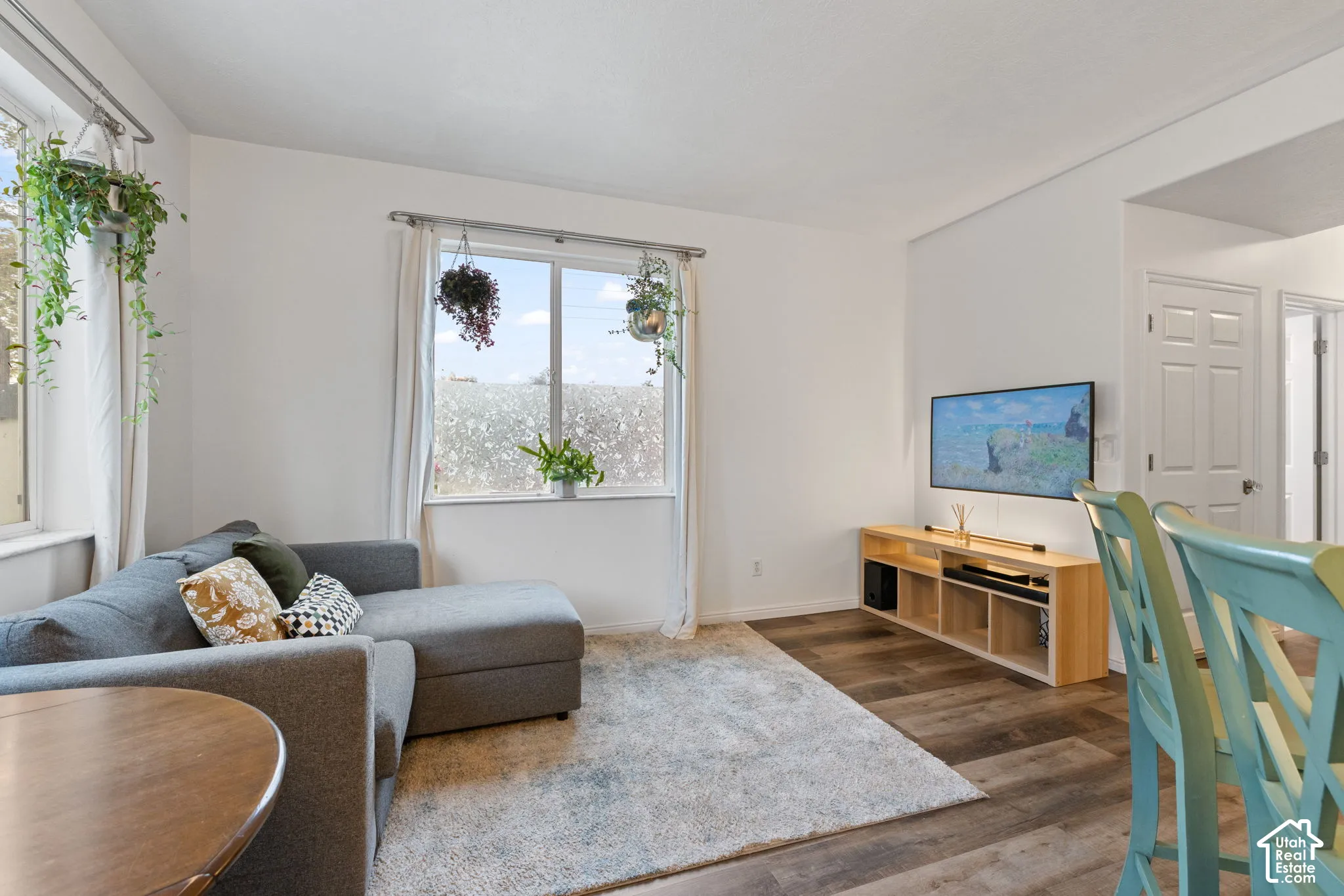 Bright living space featuring dual windows, wood-finish flooring, and a neutral color palette