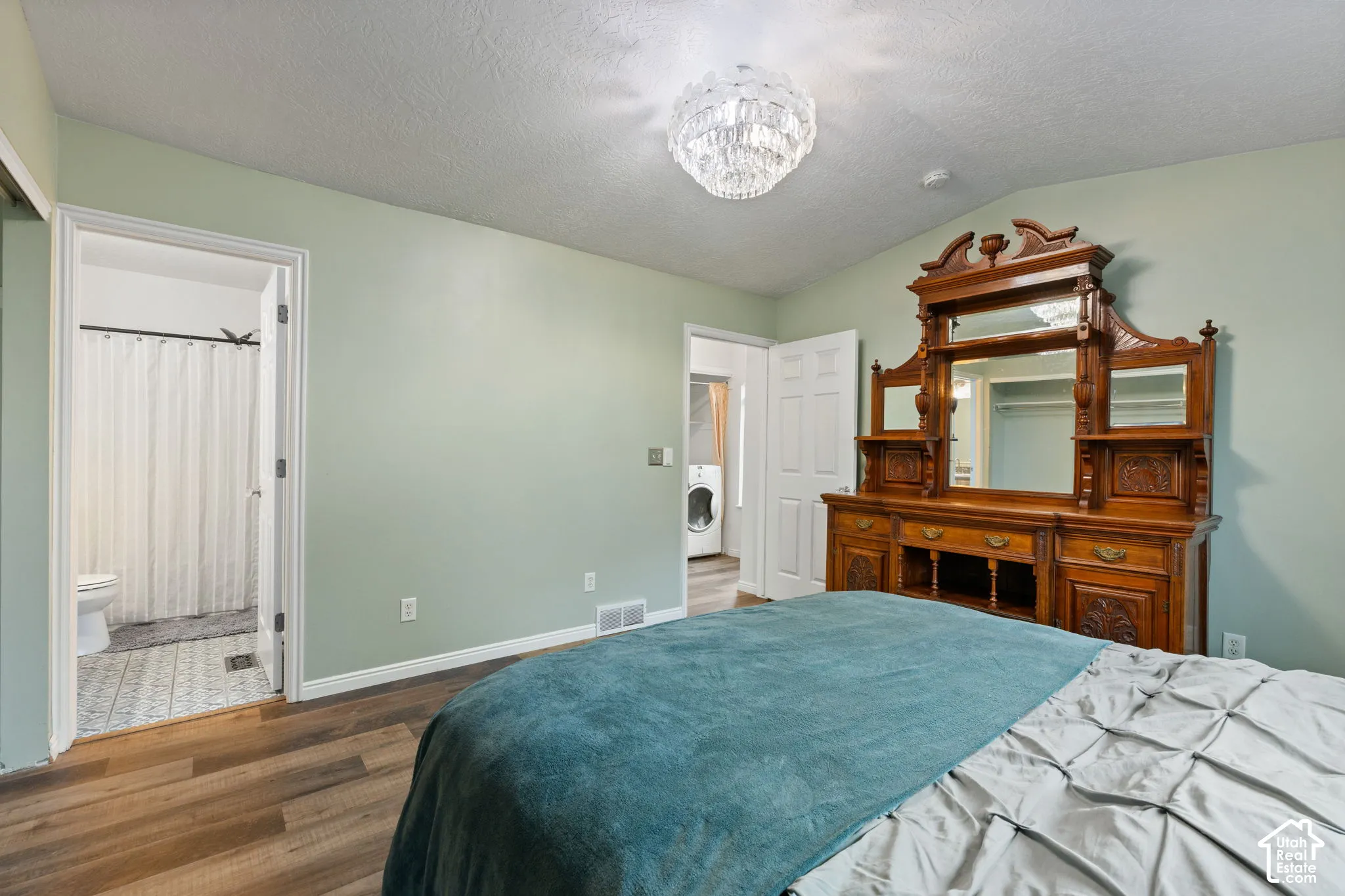 Wood-finish flooring throughout, with a crystal chandelier and light green wall paint