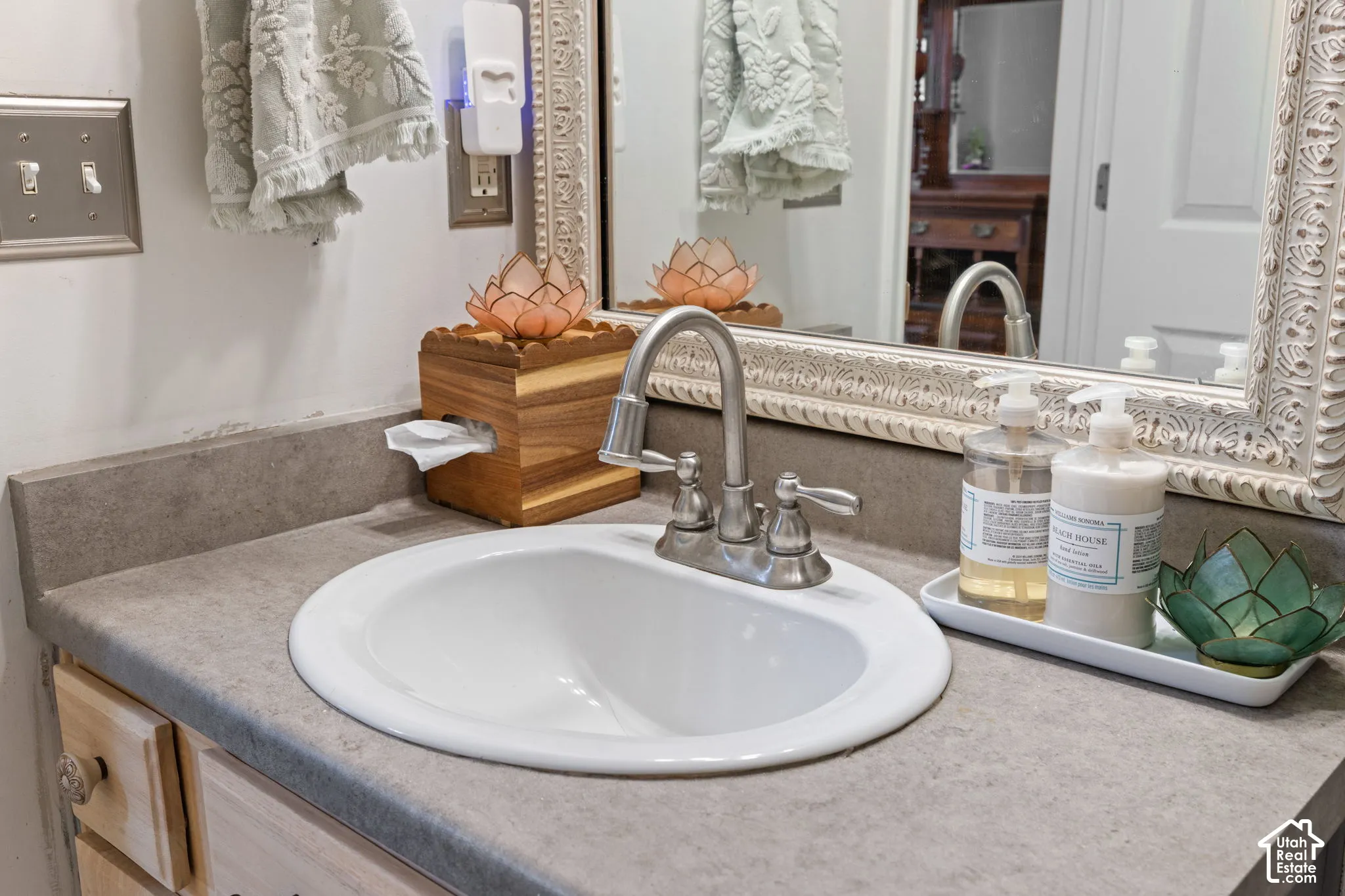 Vanity featuring a built-in white oval sink, brushed nickel faucet, and a grey countertop