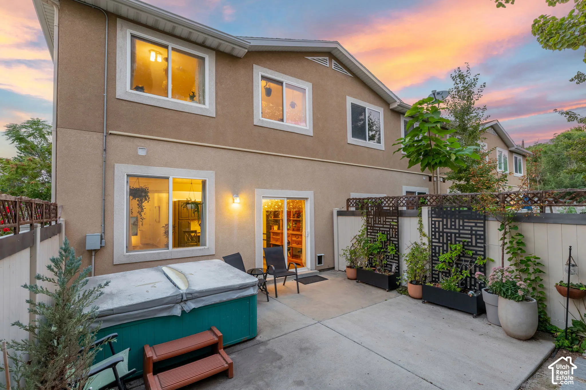 Private patio with a hot tub, stucco exterior, and sliding glass door access