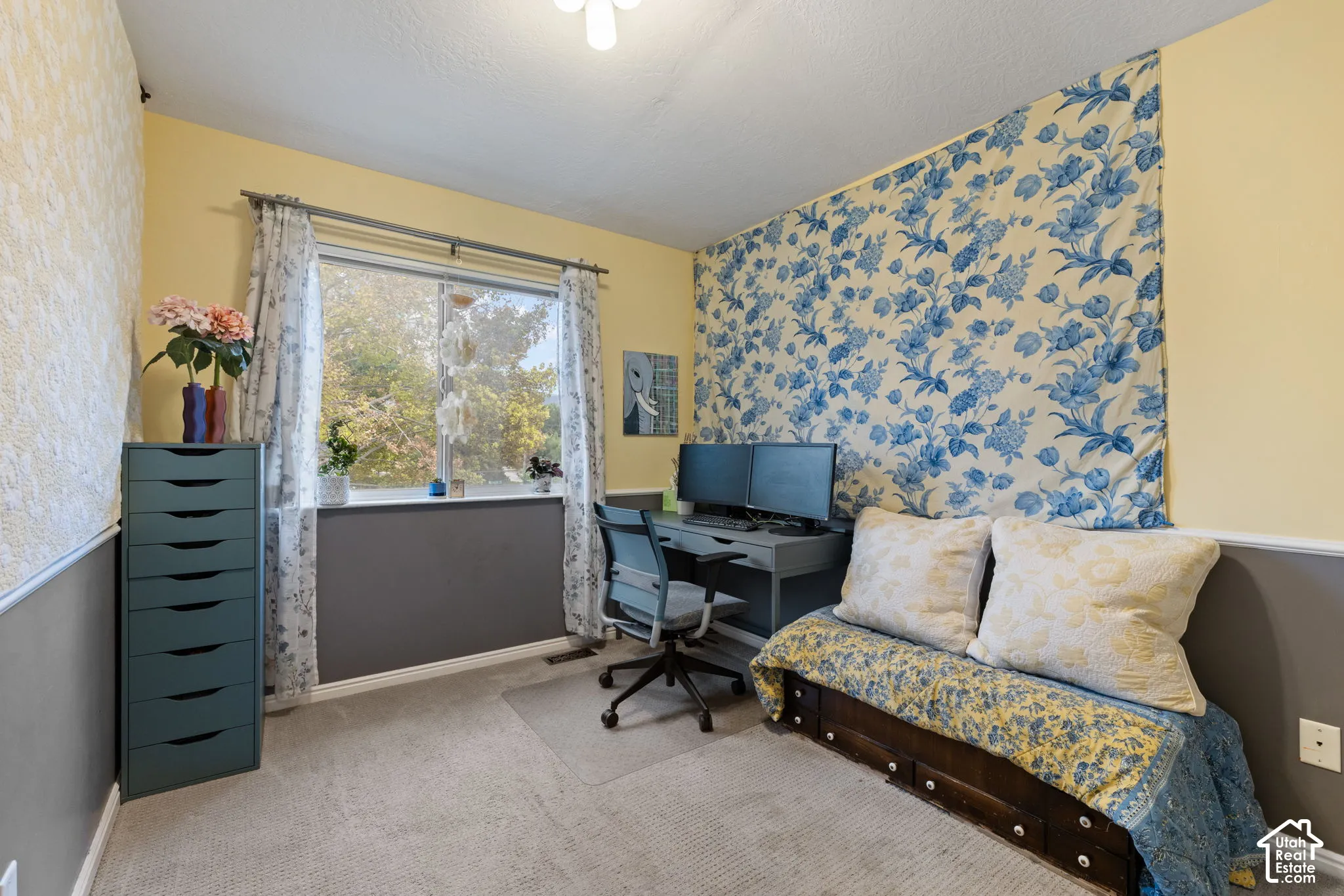 Wall-to-wall carpeting with a light-colored finish, window with a white frame, and a textured wall finish