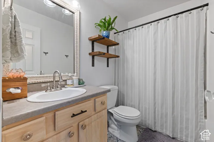 Bathroom vanity with a single basin sink, brushed nickel faucet, and natural wood cabinetry