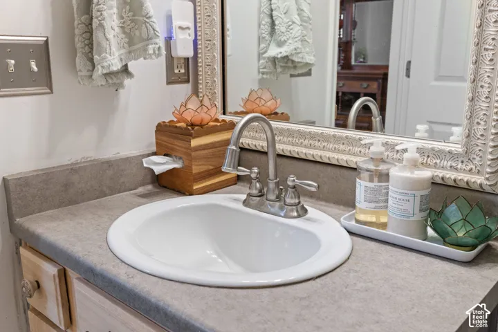 Vanity featuring a built-in white oval sink, brushed nickel faucet, and a grey countertop