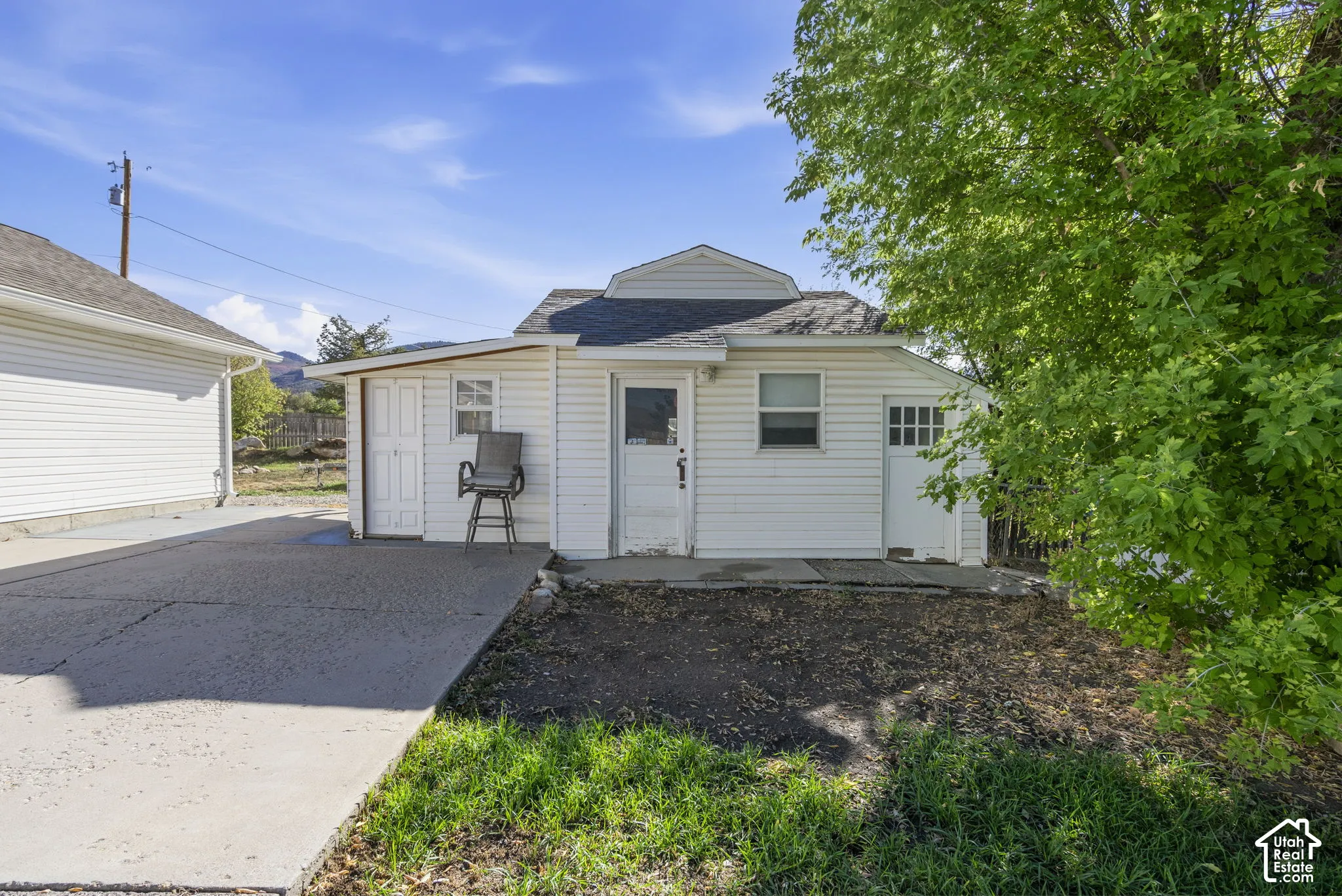 White siding exterior with a pitched roof and a concrete driveway