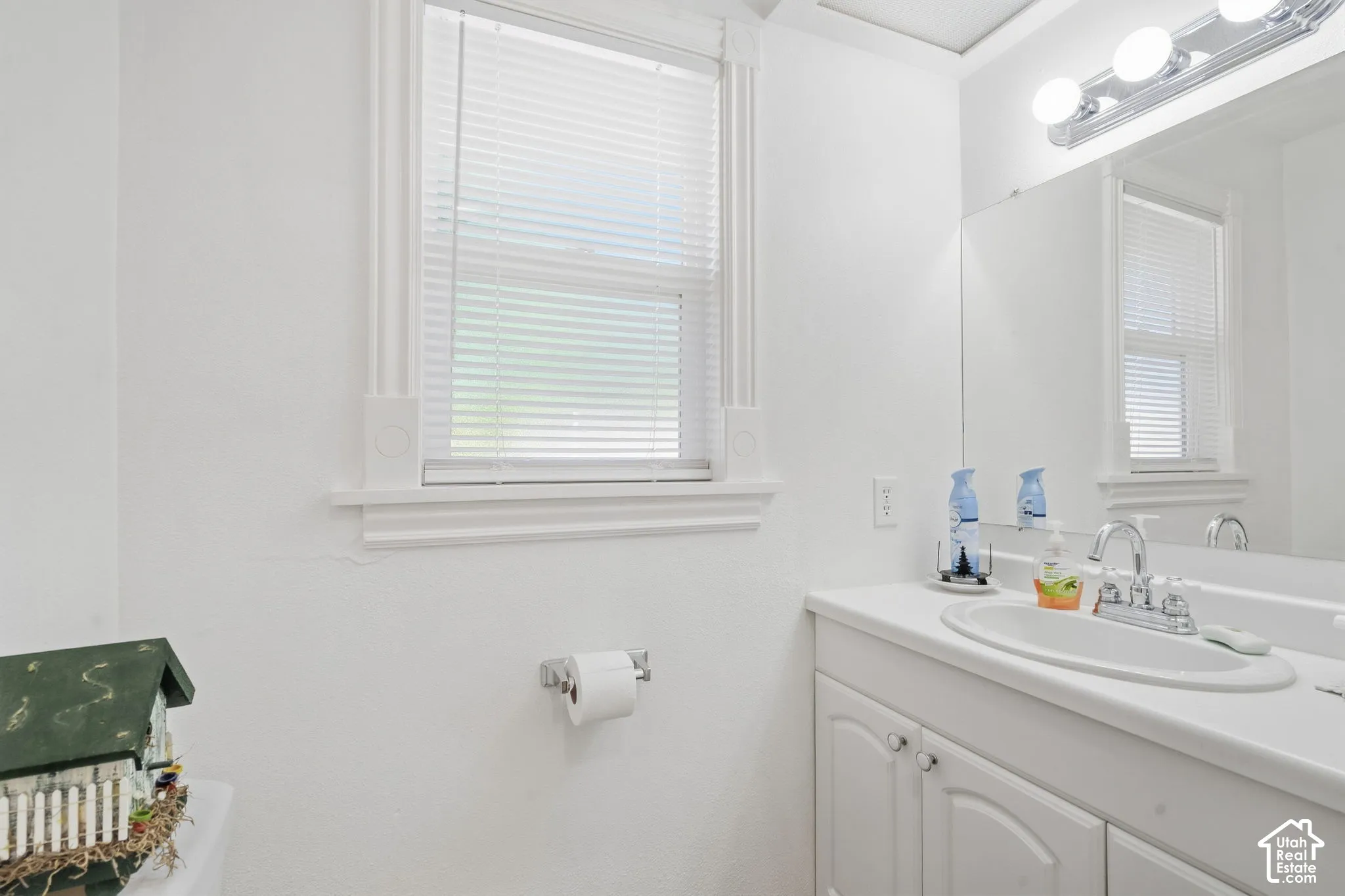White vanity with dual cabinet doors, integrated sink, and chrome faucet