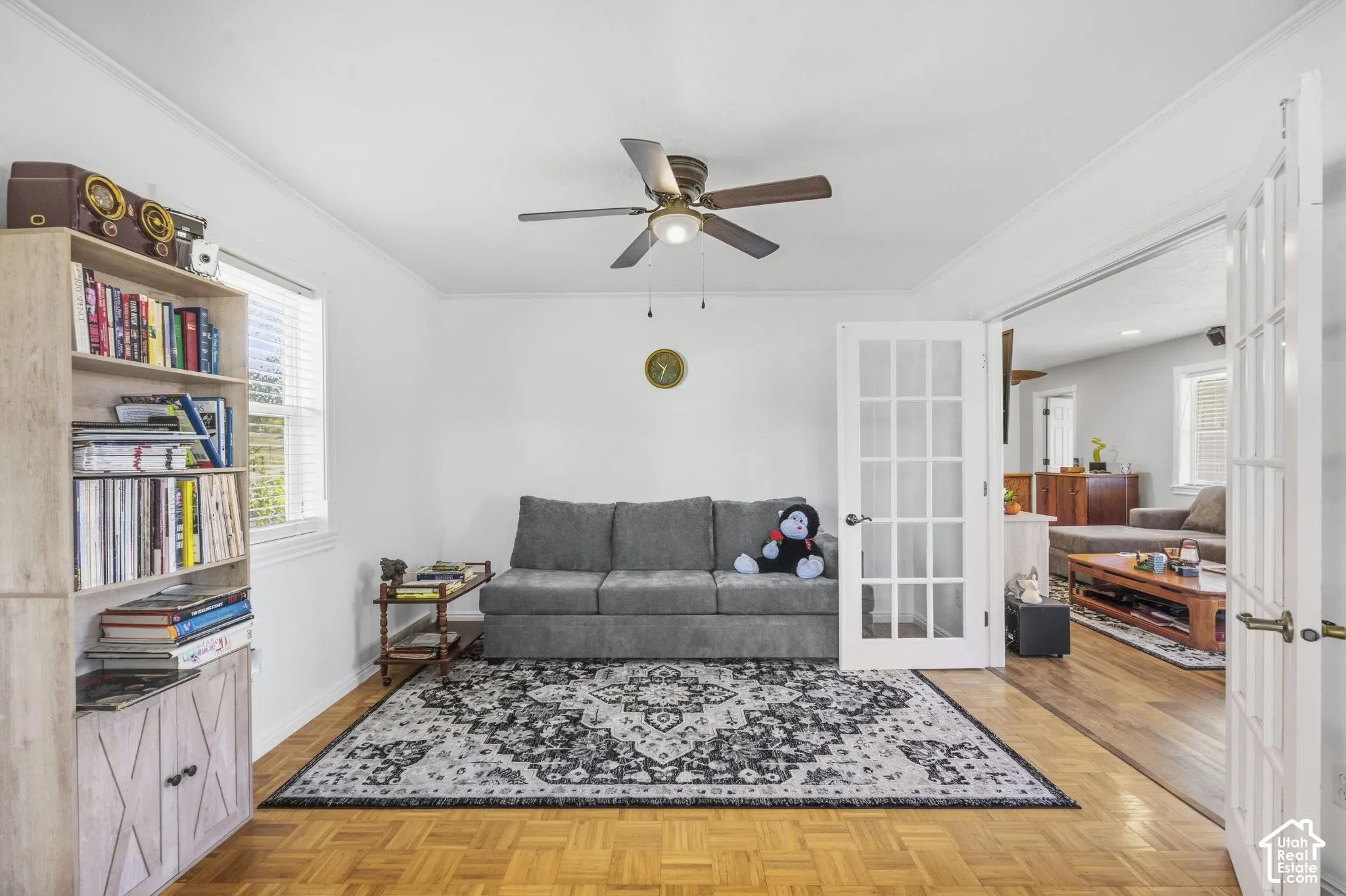 Parquet wood-finish flooring, white walls, and a ceiling fan with integrated lighting