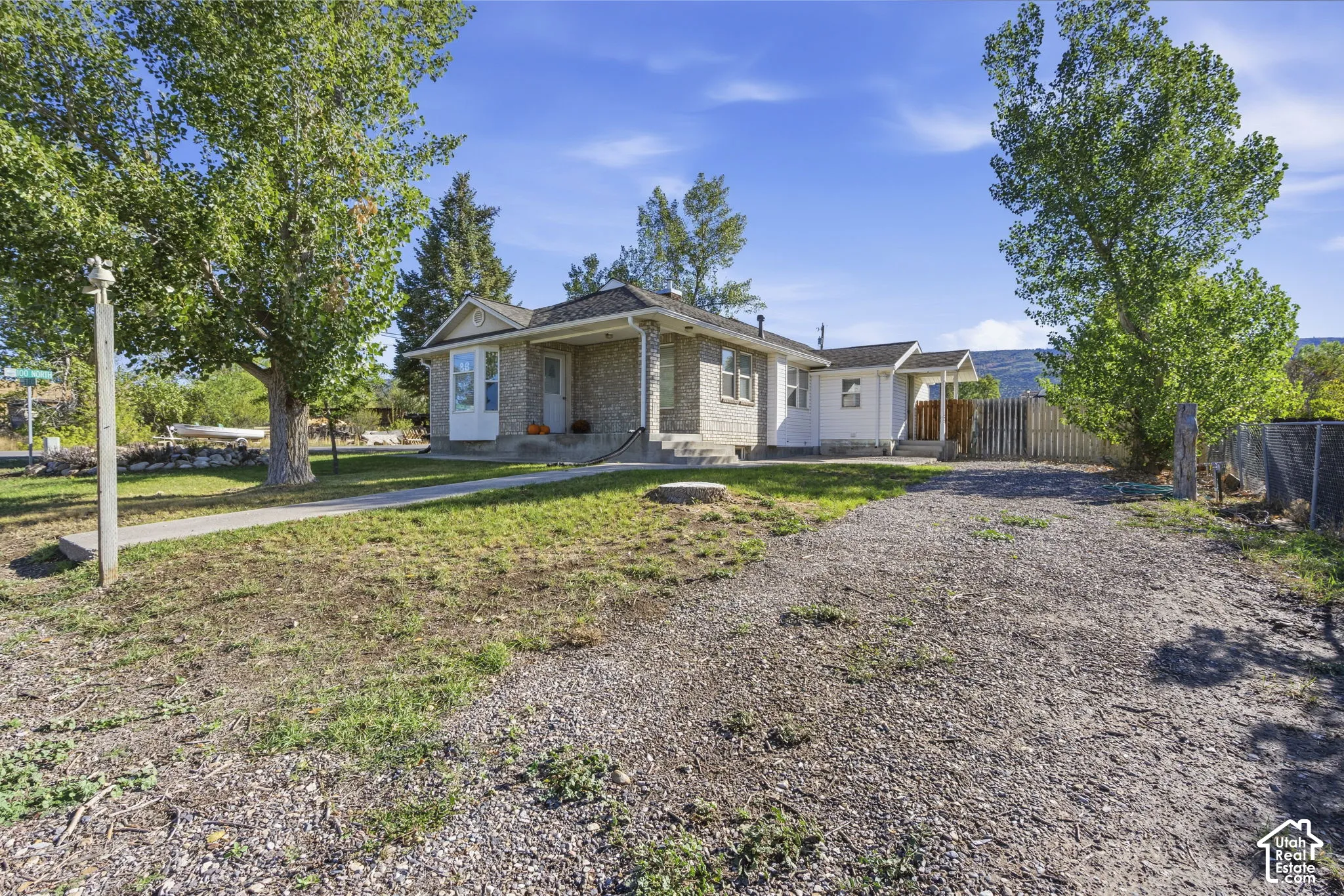 Gravel driveway leading to a white auxiliary structure