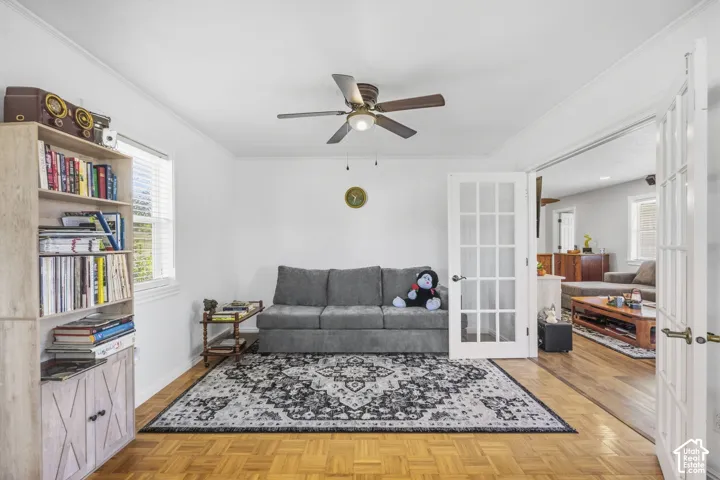 Parquet wood-finish flooring, white walls, and a ceiling fan with integrated lighting