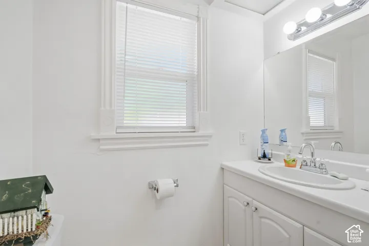 White vanity with dual cabinet doors, integrated sink, and chrome faucet