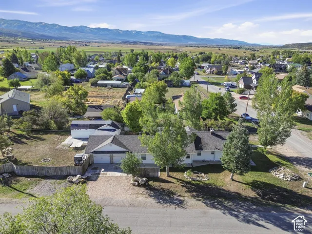 Single-story residence with a two-car garage, pitched shingle roof, and a gravel driveway