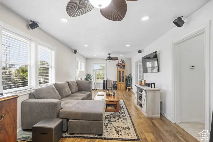 Open-concept living space featuring wood-finish flooring, recessed lighting, and multiple windows