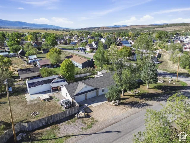 Expansive mountain backdrop, established neighborhood, two-car garage, fenced yard, and a separate outbuilding with solar panels