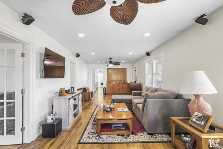 Wood-finish flooring throughout, recessed ceiling lighting, ceiling fan with wood-look blades, and white interior walls