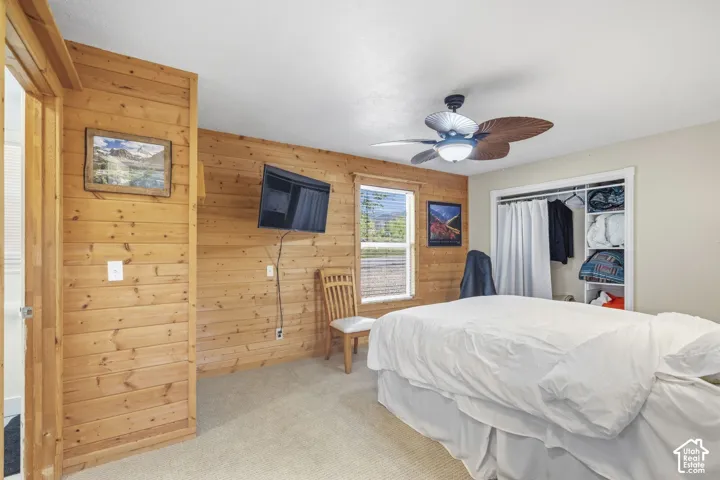Wood-paneled wall accents and a ceiling fan with integrated lighting