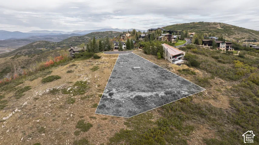 Expansive building lot with surrounding mountain terrain and distant mountain ranges