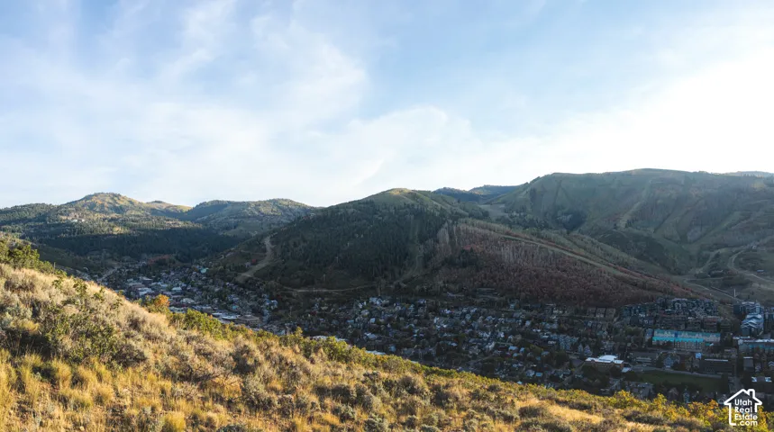 Expansive mountainous terrain surrounding a residential area, featuring varied topography and natural vegetation