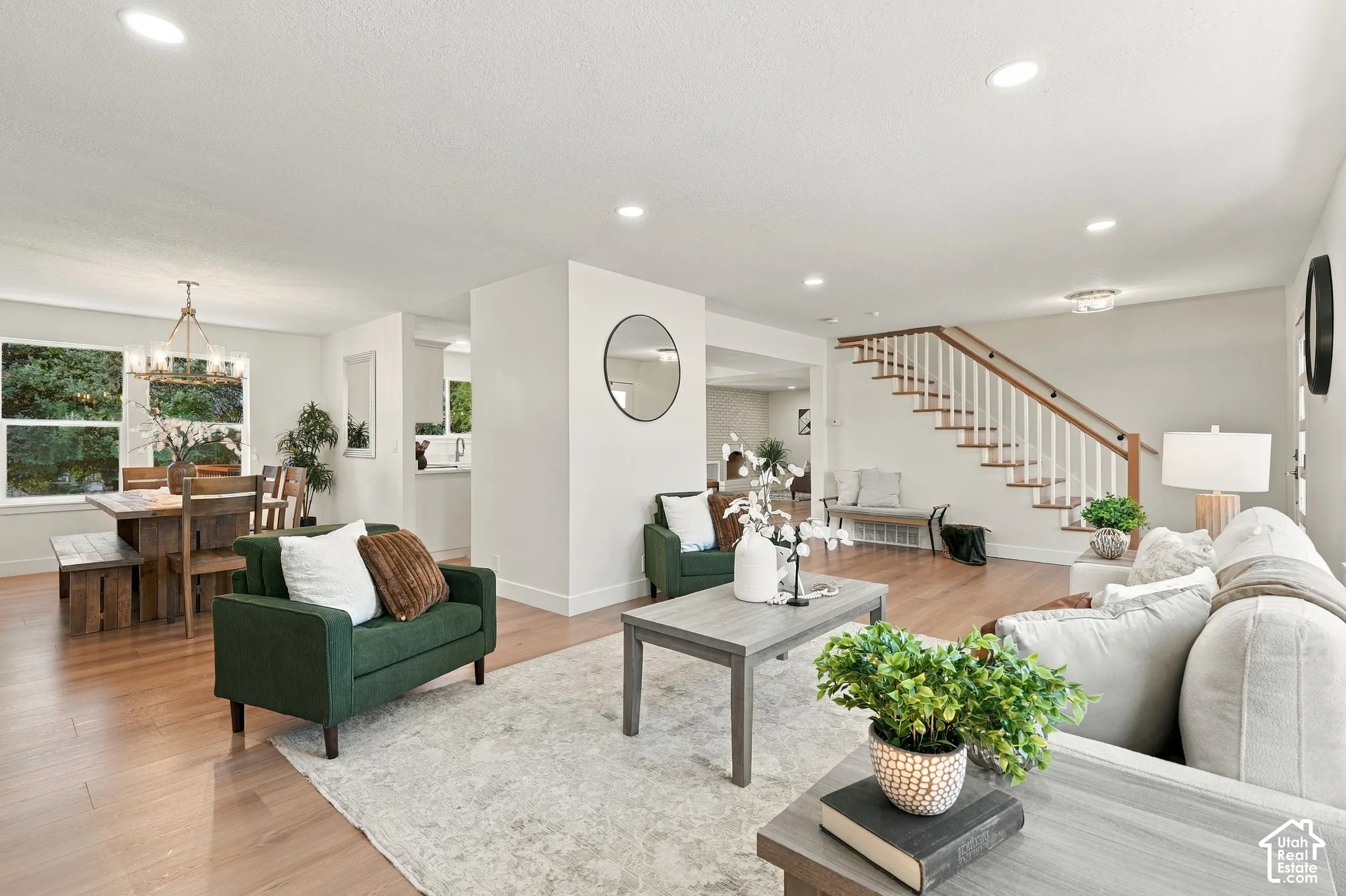 Recessed lighting illuminates the open-concept living space with wood-finish flooring