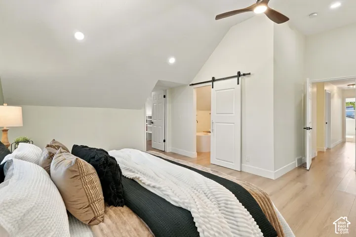Primary Bedroom Suite with Vaulted Ceilings and Ensuite AccessThis generous bedroom features soaring vaulted ceilings with recessed lighting and a ceiling fan, hardwood flooring throughout, and abundant natural light