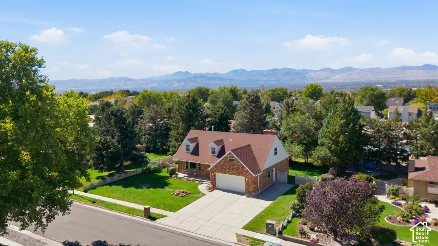 Charming brick Colonial with peaked roofline and attached two-car garage situated on manicured grounds