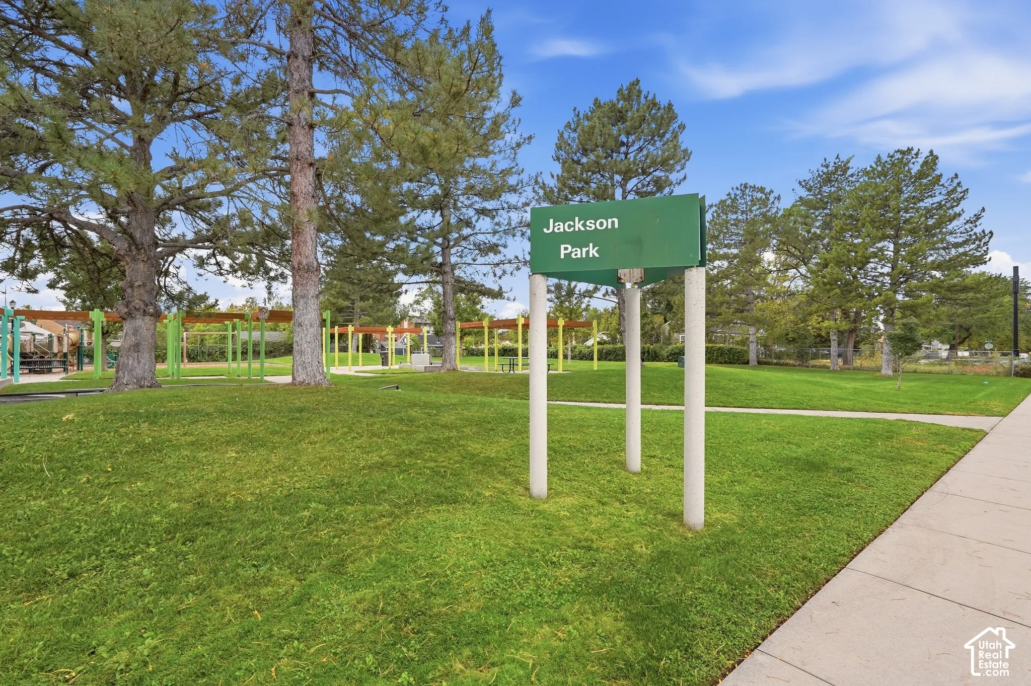 Expansive green space featuring mature trees and a paved walkway