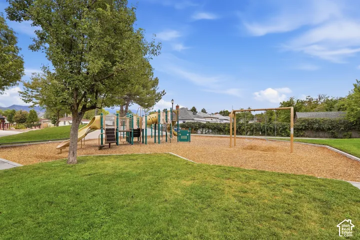 Expansive outdoor playground with mulched ground cover and a swing set