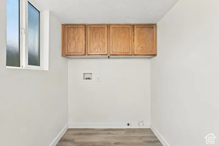 White-framed window, built-in upper cabinetry, wood-finish flooring, and white walls