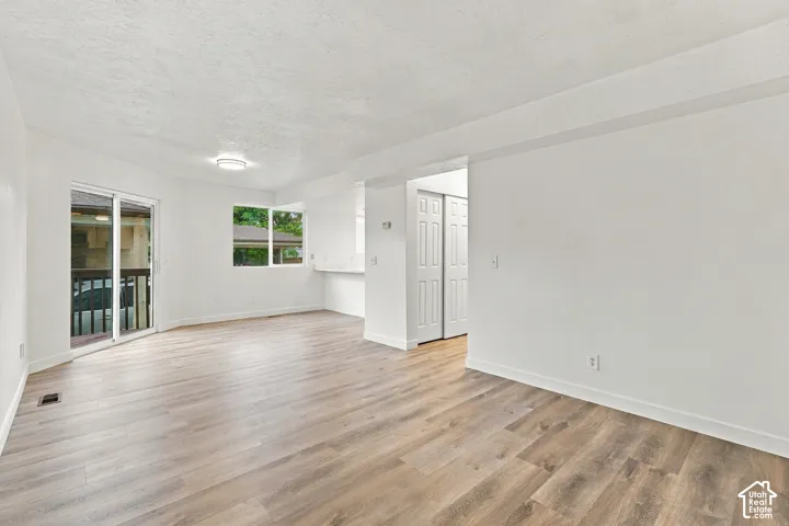Wood-finish flooring, white walls, sliding glass door, fixed windows, and a built-in counter