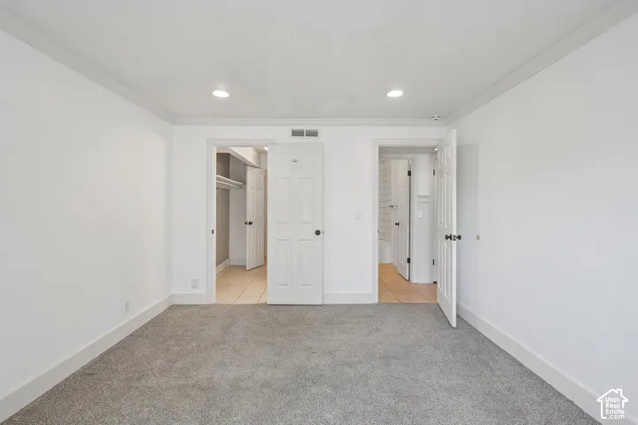 Recessed lighting, crown molding, gray carpet flooring, and white interior doors