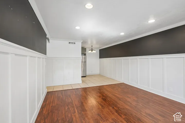 Wood-finish flooring, recessed lighting, and elegant wainscoting