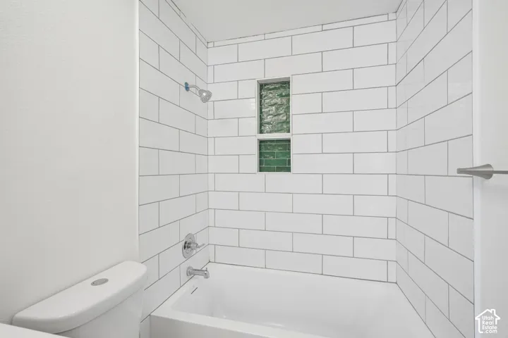 Subway tile shower surround with a built-in niche featuring green glass block accents