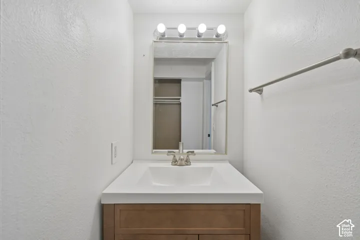 Vanity with integrated sink, brushed nickel faucet, and wood-finish cabinetry