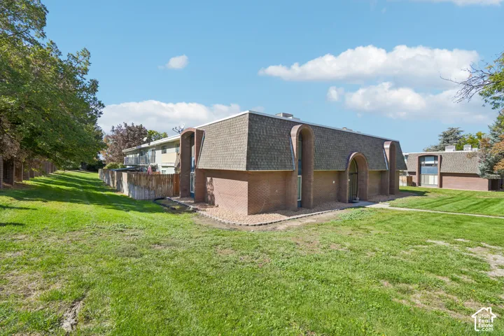 Brick exterior with arched entryways and shingle roofing