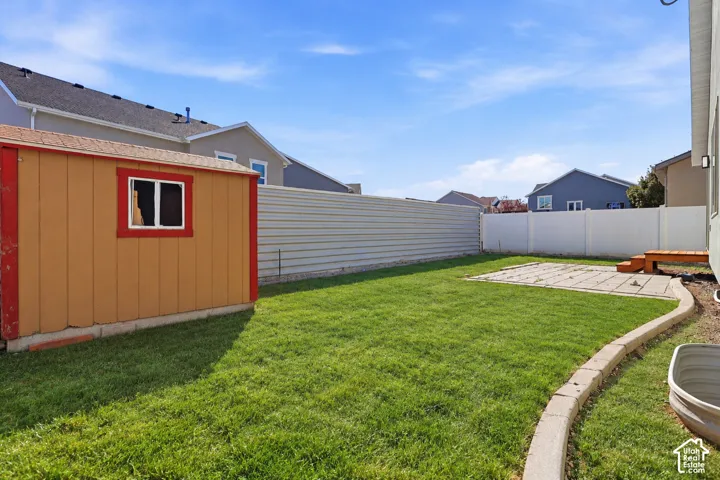 Rambler with stone accent siding, back patio, and storage shed