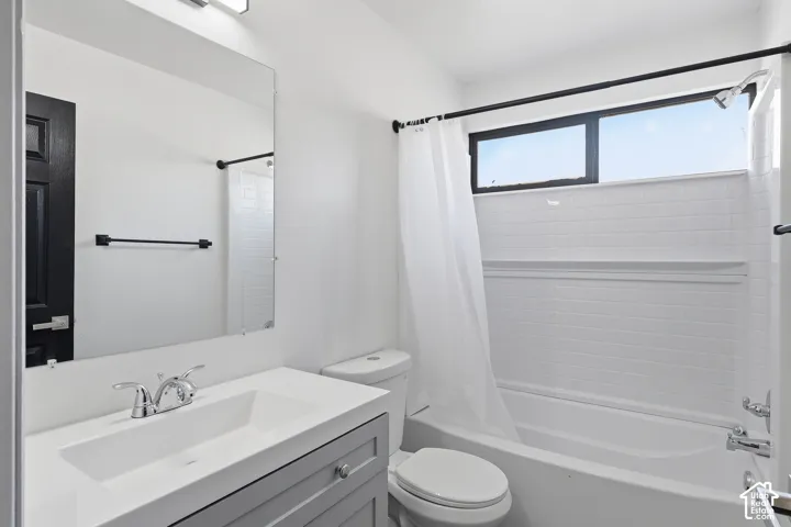 Bathroom featuring a built-in vanity with integrated sink, chrome faucet, wall-mounted mirror, and white subway tile tub/shower surround