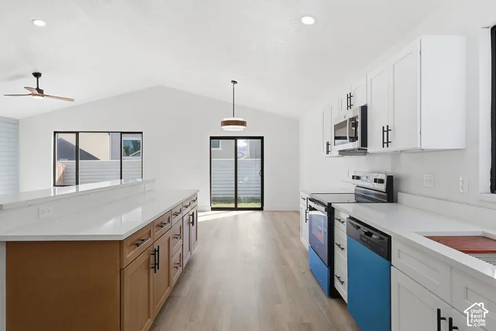 Vaulted ceiling, recessed lighting, LVP-finish flooring, island with light countertop, and white cabinetry. Brand new appliances.