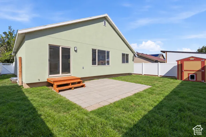 Rambler with stone accent siding, back patio, and storage shed