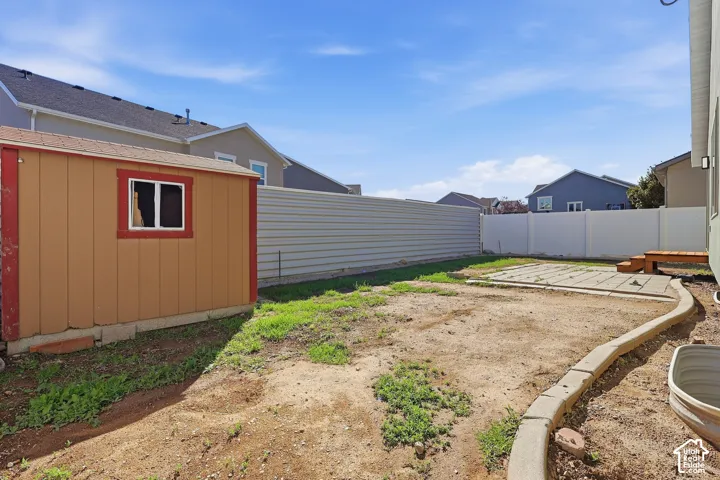 Rambler with stone accent siding, back patio, and storage shed