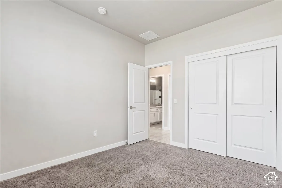 Neutral wall color, carpeted flooring, white trim, and sliding closet doors