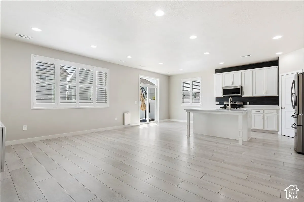 Open-concept living space with light wood-finish flooring
