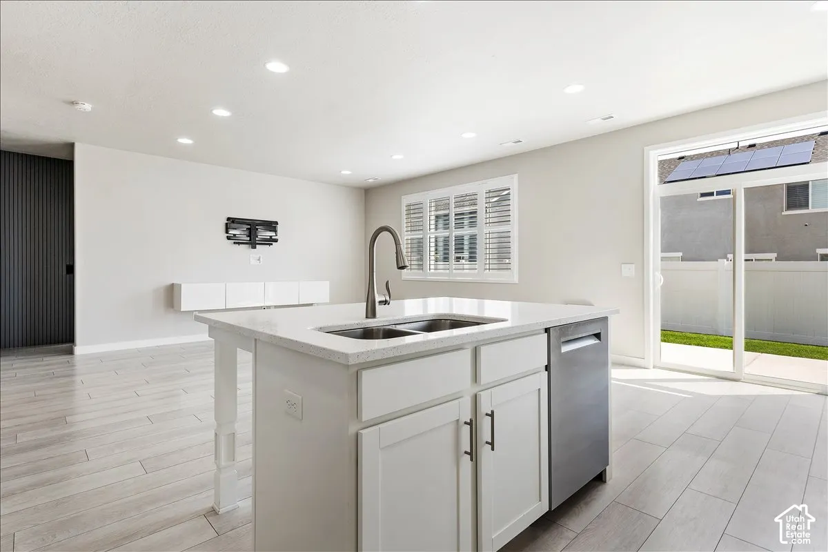 Kitchen island with an undermount dual-basin sink, gooseneck faucet, and white shaker-style cabinetry