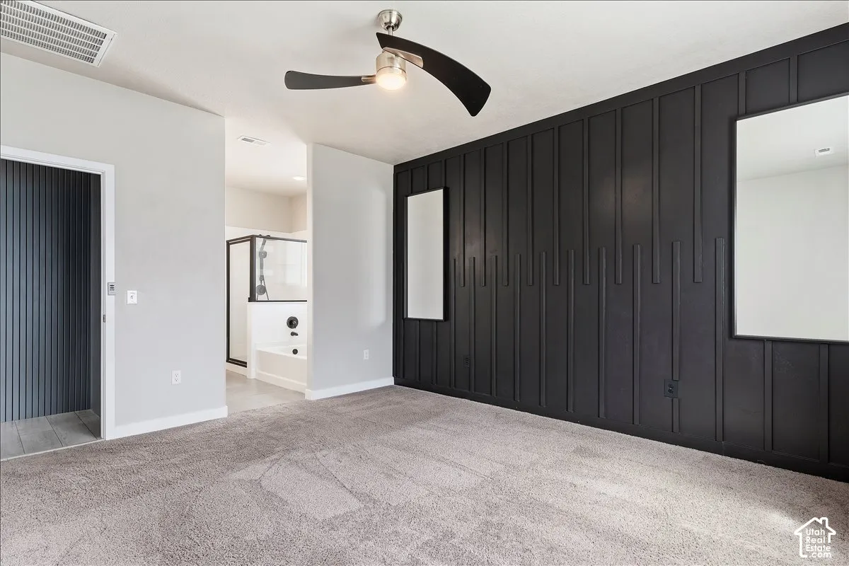 Plush carpeting, contemporary accent wall, recessed lighting, ceiling fan, and an en-suite bathroom featuring a glass-enclosed shower