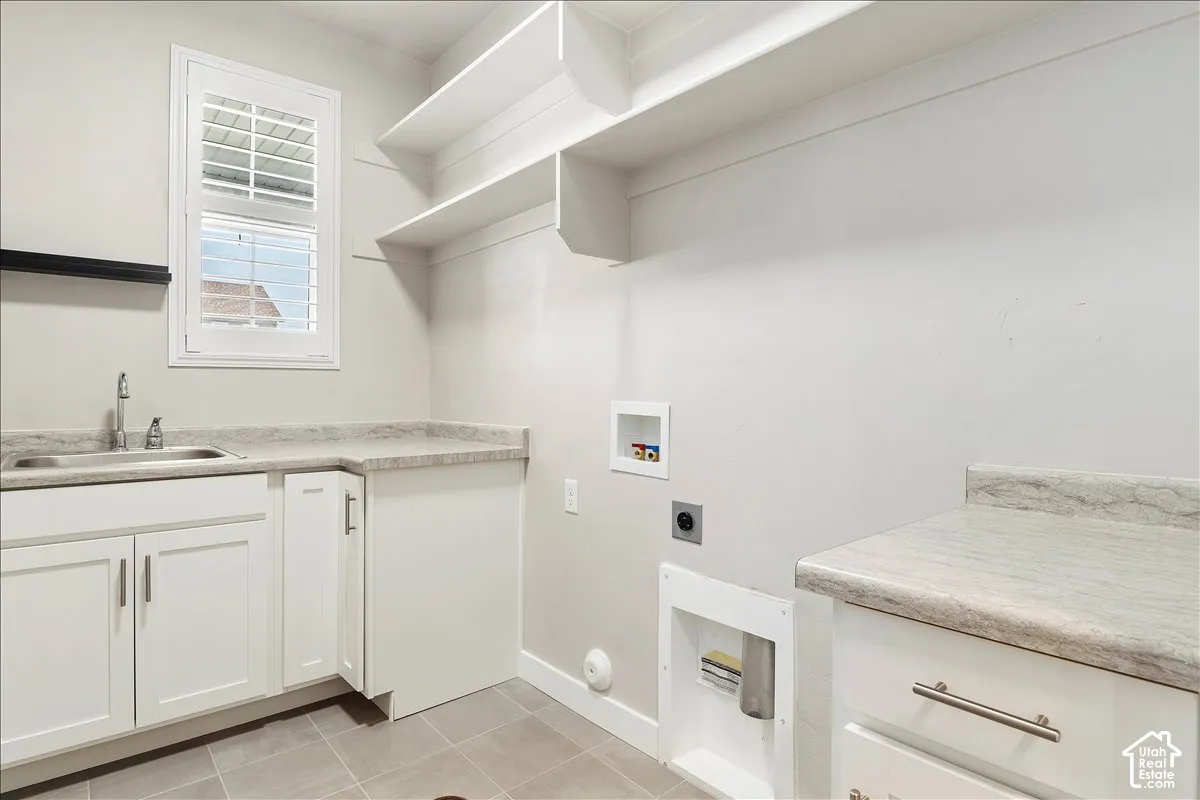 White cabinetry, light-toned countertops, and a stainless steel sink with a chrome faucet