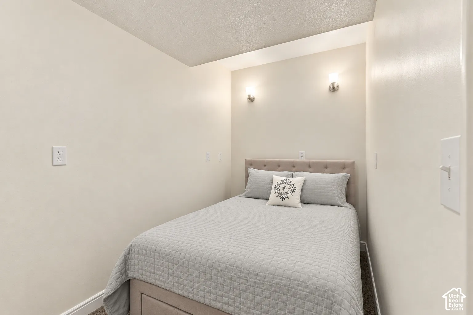 Recessed lighting, neutral wall tones, and wall-mounted sconces
