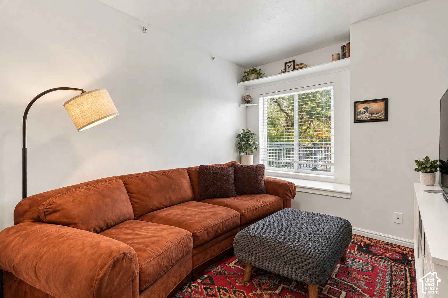 White walls with accent shelving, window with blinds, and white trim