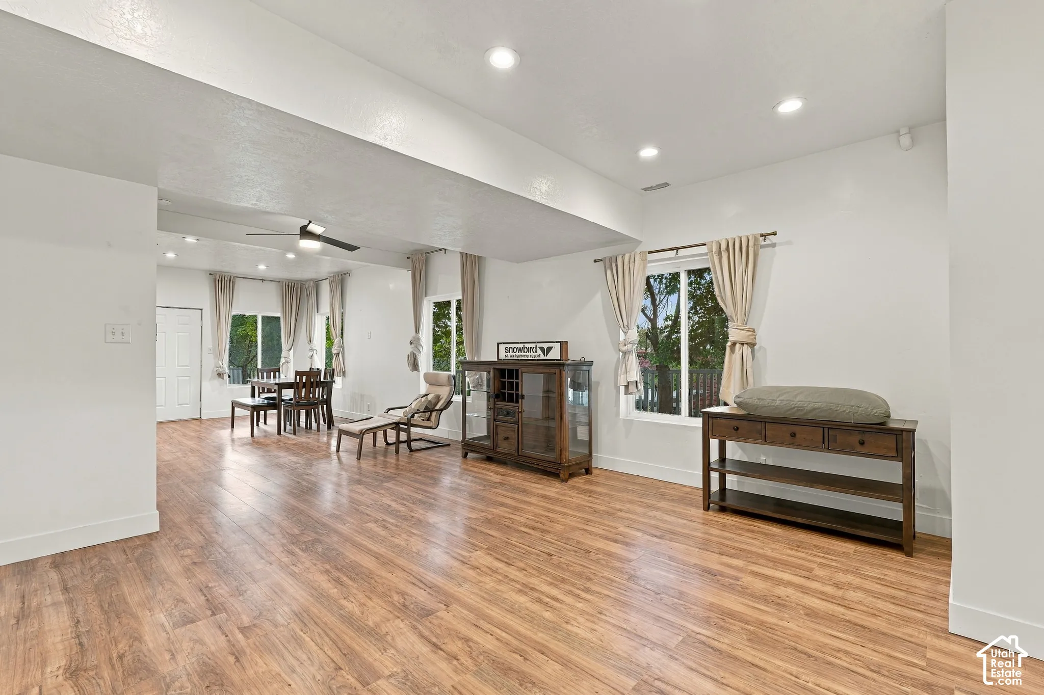 Open-concept living space featuring wood-finish flooring, recessed lighting, and multiple windows